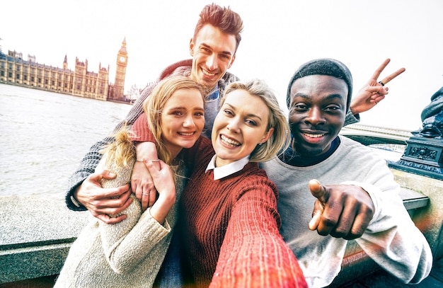 Felice gruppo di amici multirazziali che si fanno selfie a Londra durante un viaggio europeo