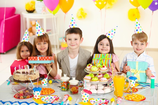 Felice gruppo di bambini con scatole regalo alla festa di compleanno