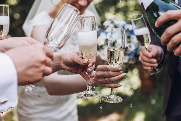 Felice gruppo di persone che brindano con champagne donna che tiene un bicchiere di champagne sposa damigelle d'onore e testimoni dello sposo che si divertono a festeggiare il natale