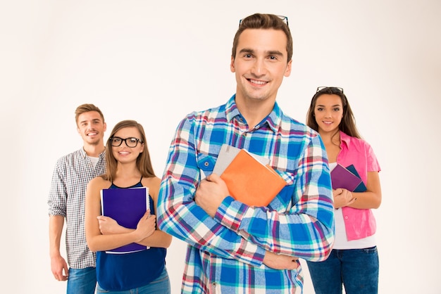 Felice gruppo fiducioso di studenti in possesso di libri e materiali