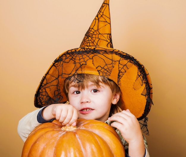 Felice Halloween. Bambino in cappello da strega con zucca Jack. Costume di carnevale. Festa di Halloween.