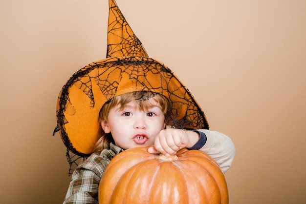 Felice halloween carino ragazzo con cappello da strega con zucca di halloween jack o lantern dolcetto o scherzetto halloween