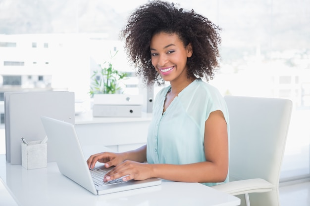 Felice imprenditrice lavorando sul suo computer portatile