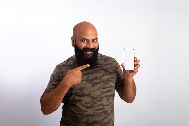 Felice indiano forte sano uomo calvo di mezza età che punta al telefono cellulare con schermo vuoto