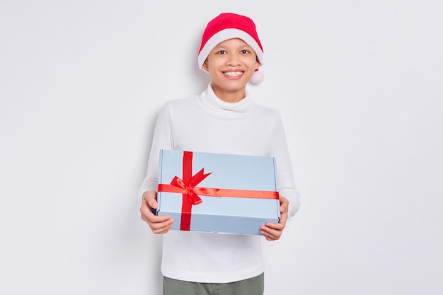 Felice l'uomo asiatico nel cappello di Natale che tiene presente confezione regalo isolato su sfondo bianco Uomo che ottiene il regalo da Babbo Natale