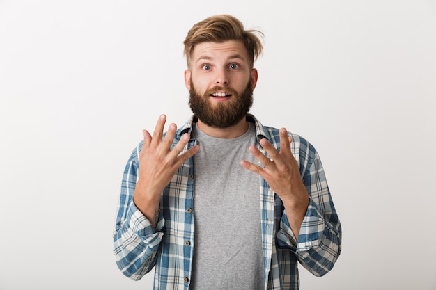 Felice l'uomo barbuto vestito in camicia a quadri in piedi isolato, celebrando il successo