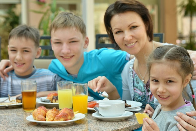 Felice madre e bambini a colazione in un resort tropicale