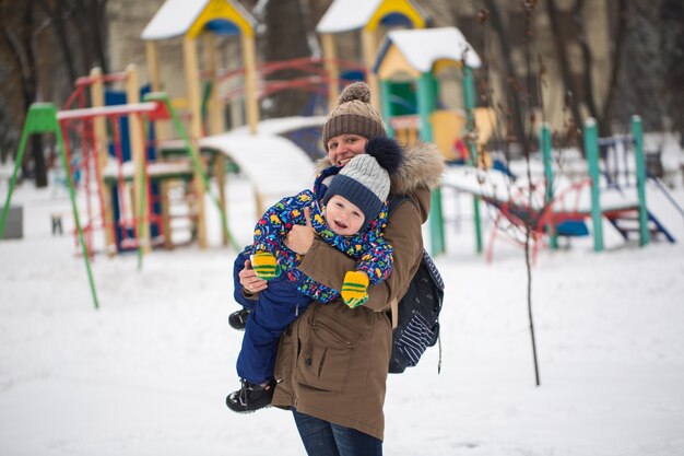 Felice madre e bambino nel parco invernale. famiglia all'aperto. mamma allegra con il suo bambino