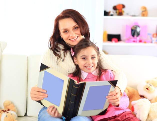 Felice madre e figlia che leggono un libro insieme