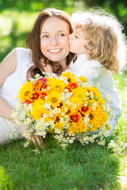 Felice madre e figlia con un grande mazzo di fiori primaverili che si divertono all'aperto