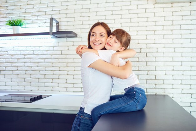 Felice madre e figlia stanno abbracciando in casa. Festa della mamma.