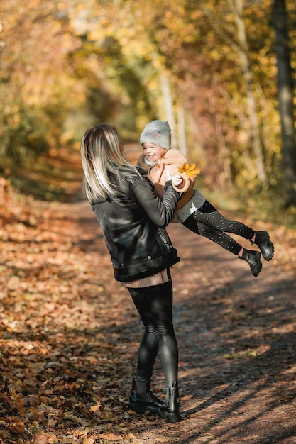 Felice madre e figlia stanno camminando nel parco autunnale Bella famiglia in abiti caldi Autunno