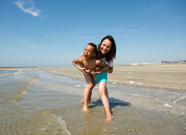 Felice madre e figlio che giocano in spiaggia