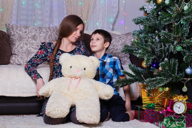 Felice mamma e figlio a casa festeggiano l'atmosfera di Natale Capodanno Albero di Natale e regali