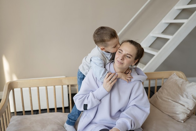 Felice mamma e figlio si abbracciano, trascorrono del tempo a casa insieme.