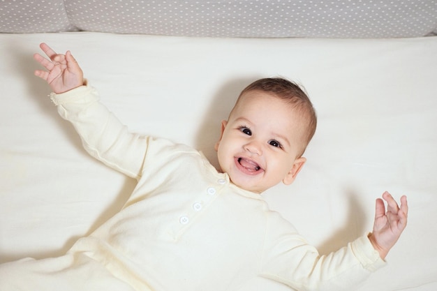 Felice neonato fa una faccia buffa Ritratto di un bambino strisciante nella sua stanza da vicino
