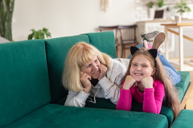 Felice nipote e nonna sdraiata sul divano in posa divertente nonna che si diverte con il nipote