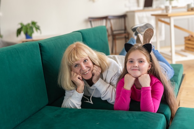 Felice nipote e nonna sdraiata sul divano in posa divertente nonna che si diverte con il nipote