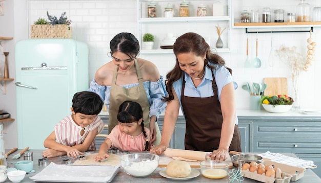 Felice nonna di famiglia asiatica con madre e bambino che preparano cibo in cucina a casa Goditi l'attività familiare insieme