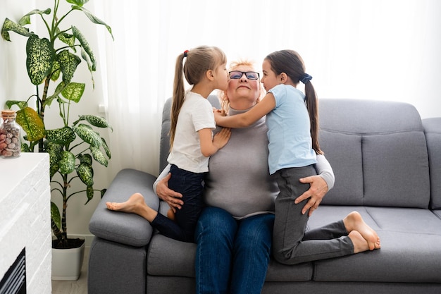 Felice nonna matura di mezza età e piccolo bambino in età prescolare due nipoti che si divertono a giocare a casa.