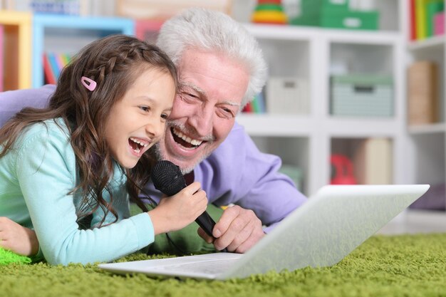 Felice nonno e bambino che cantano al karaoke