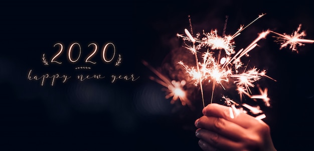 Felice nuovo anno 2020 con mano che tiene esplosione di fuochi d'artificio Sparkler