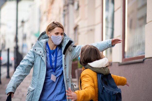 Felice operatore sanitario all'aperto in città che incontra il concetto di coronavirus della figlia della studentessa