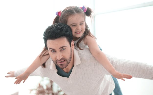 Felice padre che gioca con la figlia nel luminoso soggiorno