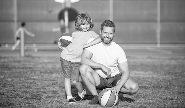 Felice padre e bambino che giocano a basket con la palla sport all'aria aperta