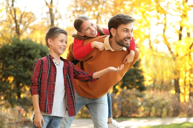 Felice padre e figli che trascorrono del tempo nel parco Passeggiata autunnale