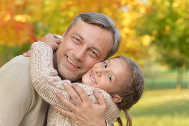 Felice padre e figlia in posa all'aperto in autunno