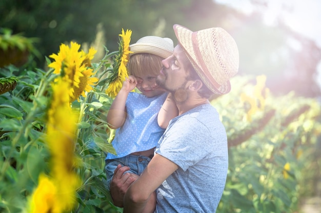 Felice padre e figlia si abbracciano nel campo dei girasoli