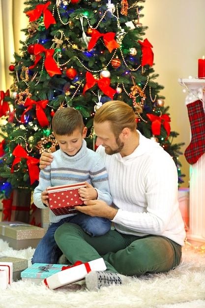Felice padre e figlio all'albero di Natale in soggiorno