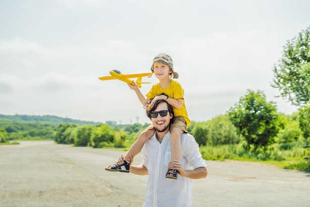Felice padre e figlio che giocano con l'aeroplano giocattolo sullo sfondo della vecchia pista Viaggiando con il concetto di bambini