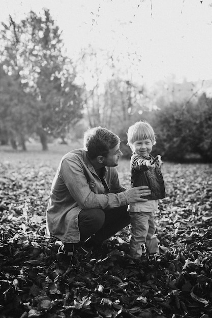 Felice padre e figlio che hanno divertimento nel parco d'autunno