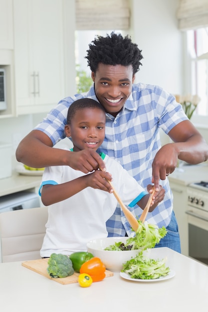 Felice padre e figlio che preparano le verdure