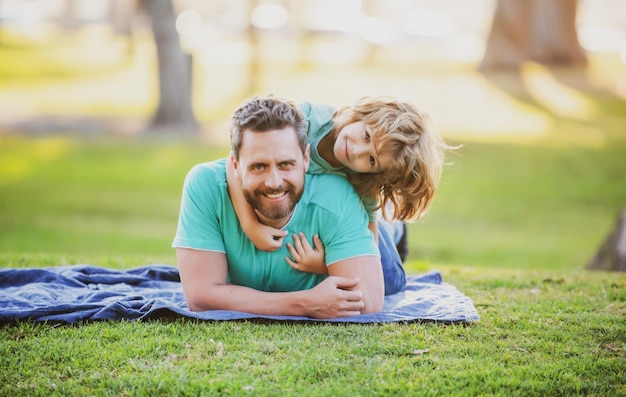 Felice padre e figlio che si godono l'estate in vacanza in un parco soleggiato