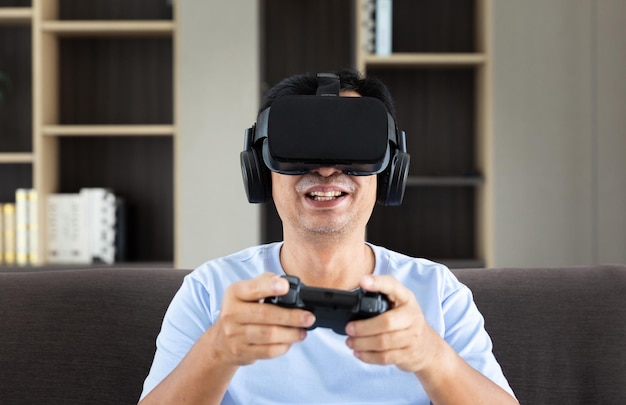 Felice padre papà maschio adulto indossa occhiali simulatore di realtà virtuale VR per giocare a videogiochi 3d con tecnologia di controllo joystick durante il fine settimana