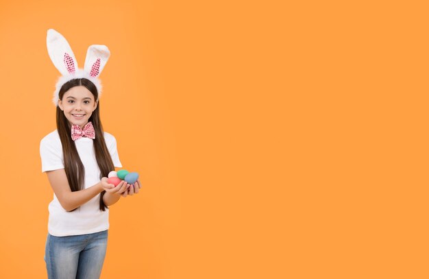 Felice pasqua bambina con orecchie da coniglio e farfallino tenere uova dipinte copia spazio pasqua