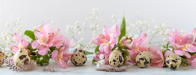 Felice Pasqua uova di quaglia piume fiori rosa primaverili su sfondo marmo banner