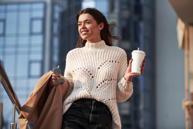 Felice primavera. La giovane bella ragazza in vestiti caldi ha passeggiata in città durante il suo tempo di fine settimana