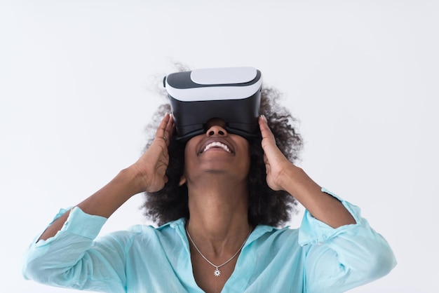 Felice ragazza afroamericana che ottiene esperienza utilizzando gli occhiali per cuffie VR della realtà virtuale, isolati su sfondo bianco