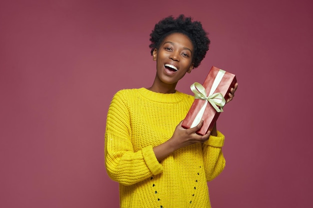 Felice ragazza afroamericana con scatola regalo regalo di compleanno vendita e vacanze di Natale