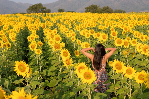 Felice ragazza al campo dei fiori in estate