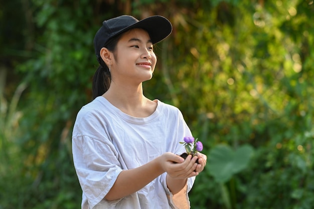 Felice ragazza asiatica mano che tiene piccolo albero per piantare Concetto di salvare la giornata mondiale della terra