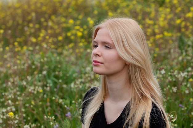 Felice ragazza bionda circondata da fiori