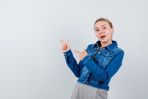 Felice ragazza che mostra la sinistra con le dita su sfondo bianco