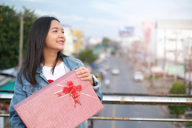 Felice ragazza con confezione regalo sullo sfondo della città