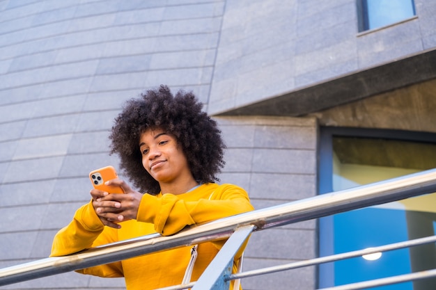 Felice ragazza di razza mista millenaria per la strada della città Giovane donna afroamericana positiva