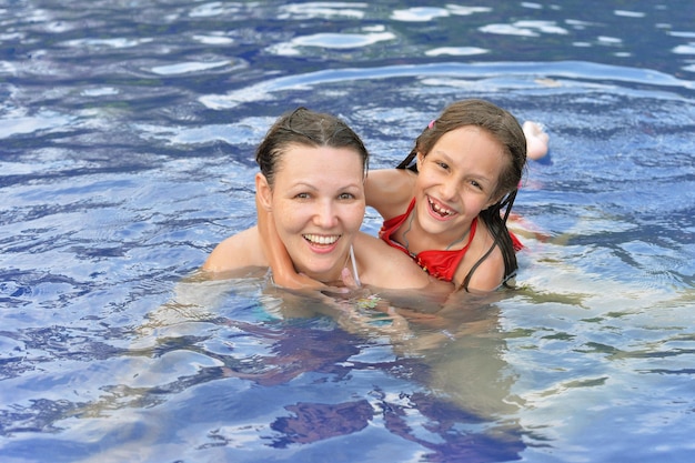 Felice ragazza e madre in piscina